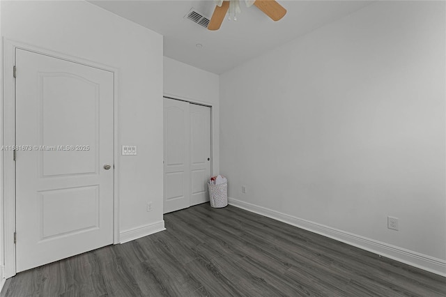 unfurnished bedroom featuring ceiling fan, dark hardwood / wood-style flooring, and a closet