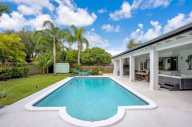 view of swimming pool featuring a lawn, a patio, ceiling fan, and exterior bar