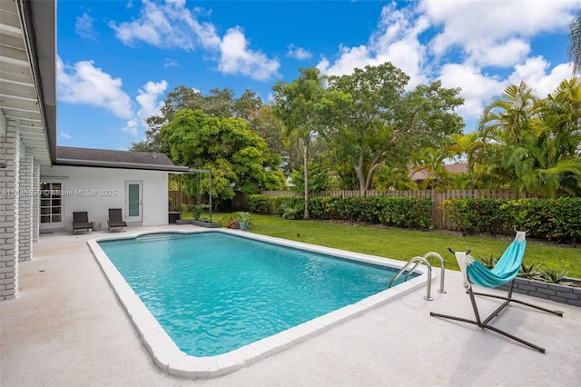 view of swimming pool with a yard and a patio area