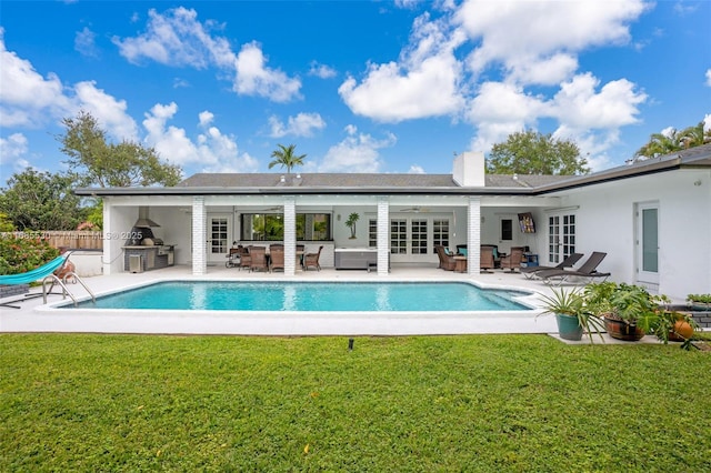 rear view of property featuring exterior kitchen, a yard, ceiling fan, a patio area, and french doors