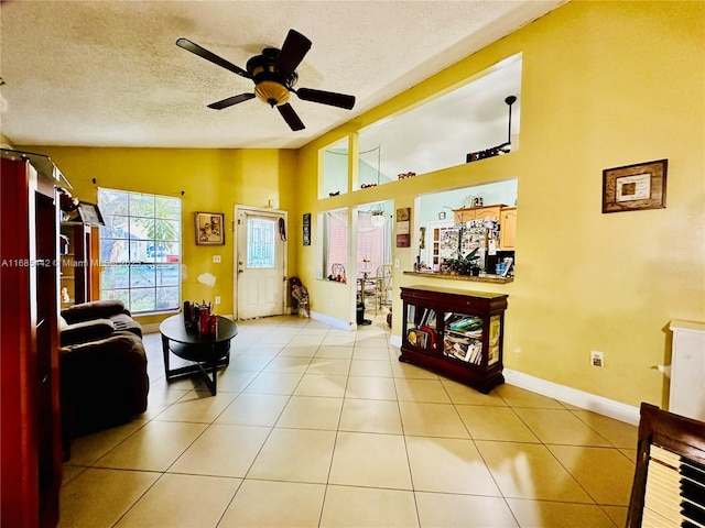 tiled living room featuring ceiling fan, vaulted ceiling, and a textured ceiling