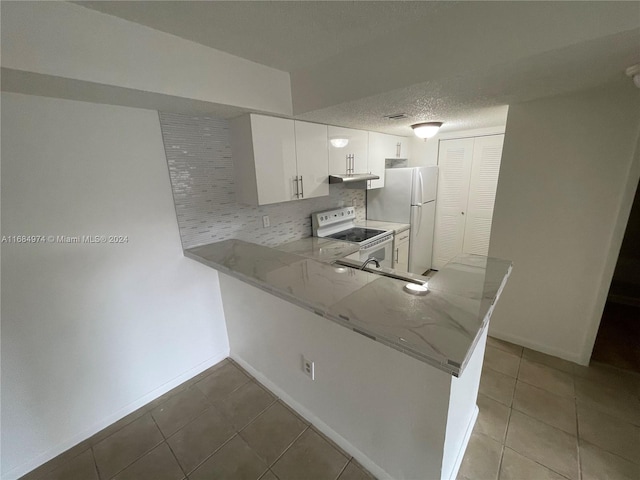 kitchen with kitchen peninsula, tasteful backsplash, white appliances, sink, and white cabinetry