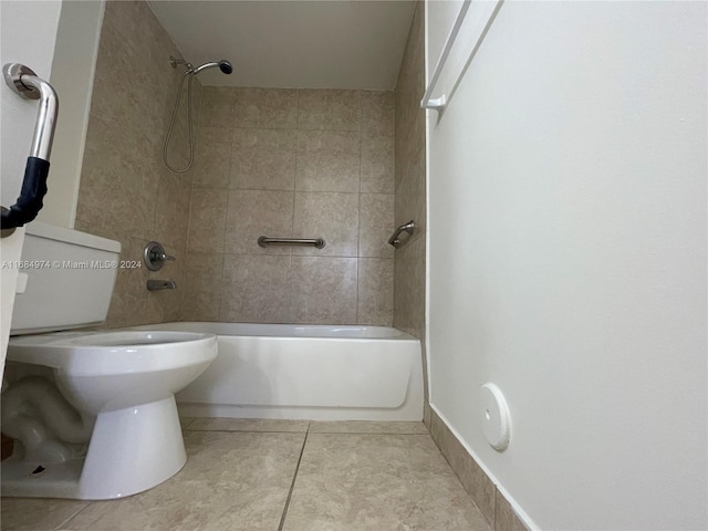 bathroom with tile patterned flooring, toilet, and tiled shower / bath