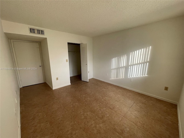 unfurnished bedroom with a textured ceiling and a closet