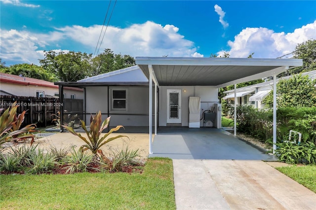 view of front of house with a carport and a front lawn