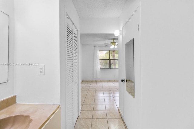 hallway featuring a textured ceiling and light tile patterned floors