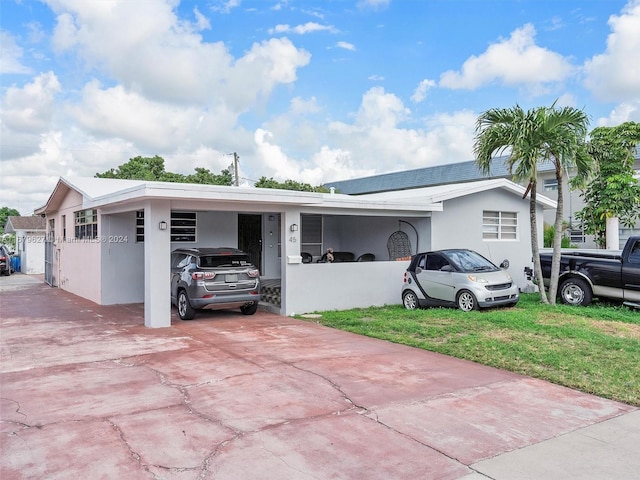 ranch-style house with a front lawn and a carport