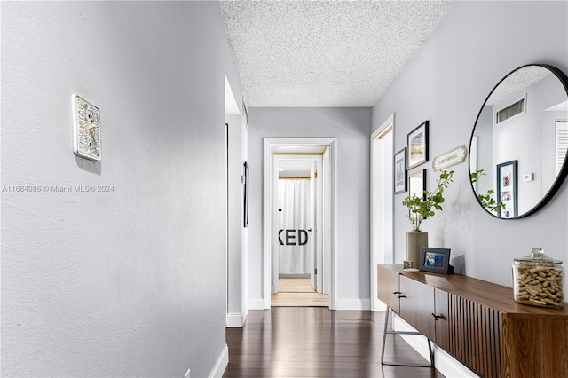 hallway featuring dark hardwood / wood-style floors and a textured ceiling