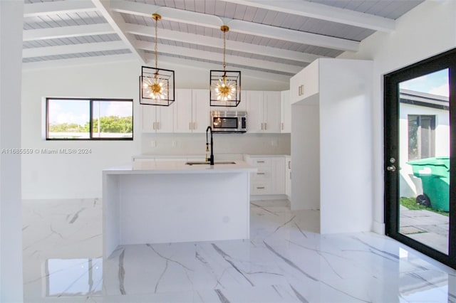 kitchen with sink, lofted ceiling with beams, hanging light fixtures, and white cabinets