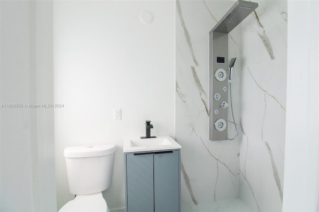 bathroom featuring vanity, toilet, and a tile shower