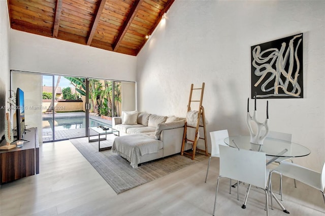 living room featuring light hardwood / wood-style flooring, beamed ceiling, high vaulted ceiling, and wood ceiling