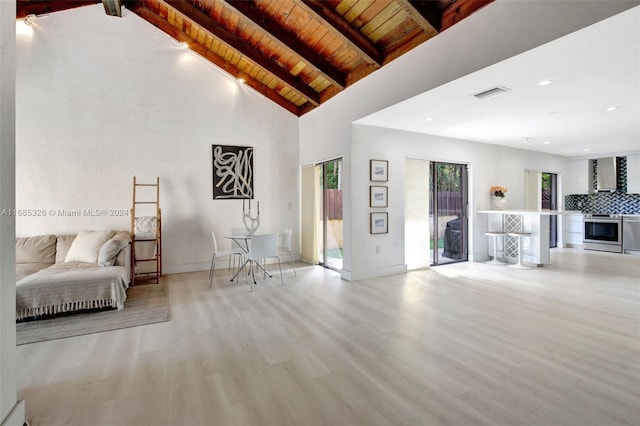 unfurnished living room with beam ceiling, high vaulted ceiling, light wood-type flooring, and wooden ceiling