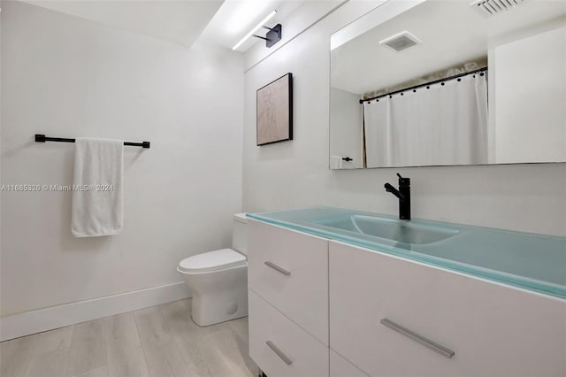 bathroom with vanity, hardwood / wood-style flooring, and toilet