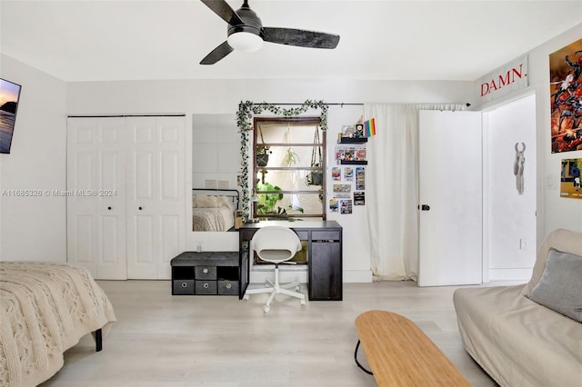 bedroom featuring a closet, ceiling fan, white fridge, and light wood-type flooring