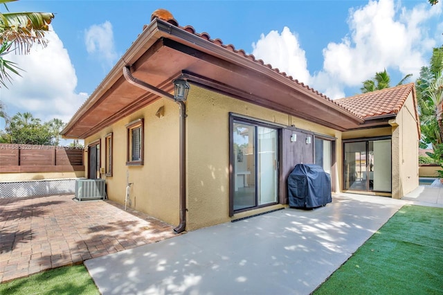 rear view of property featuring a patio and central air condition unit