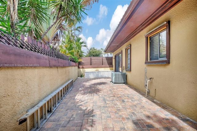 view of side of property with a patio area and central AC unit