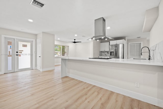 kitchen featuring kitchen peninsula, sink, island range hood, and stainless steel fridge with ice dispenser