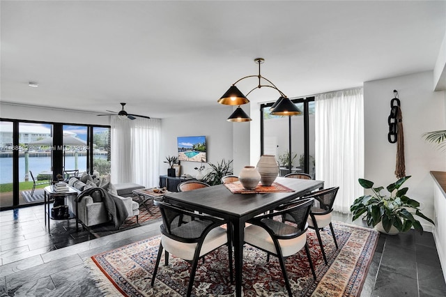 dining space featuring a water view and ceiling fan