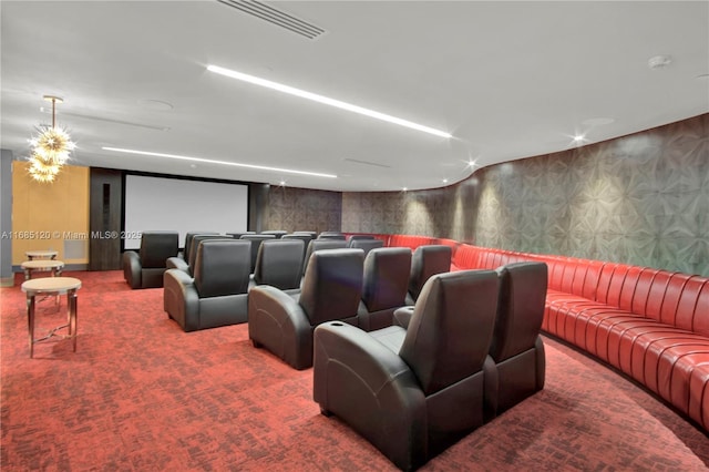 carpeted cinema room featuring wallpapered walls and an accent wall