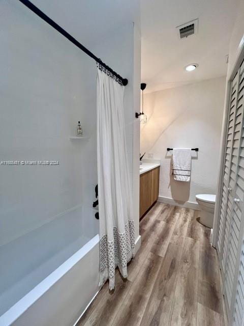 full bathroom with hardwood / wood-style flooring, vanity, toilet, and shower / bathtub combination with curtain