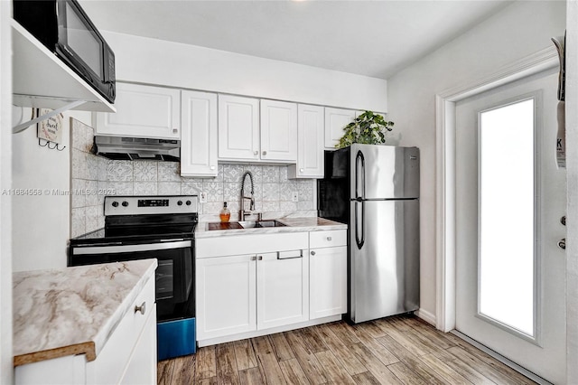 kitchen featuring sink, light stone countertops, white cabinets, and appliances with stainless steel finishes