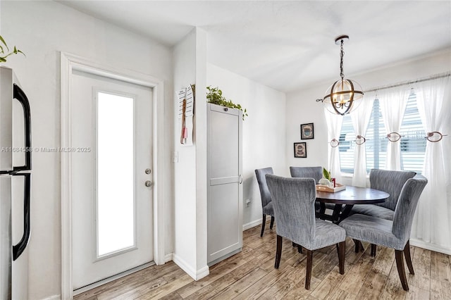 dining space featuring light hardwood / wood-style floors and a chandelier