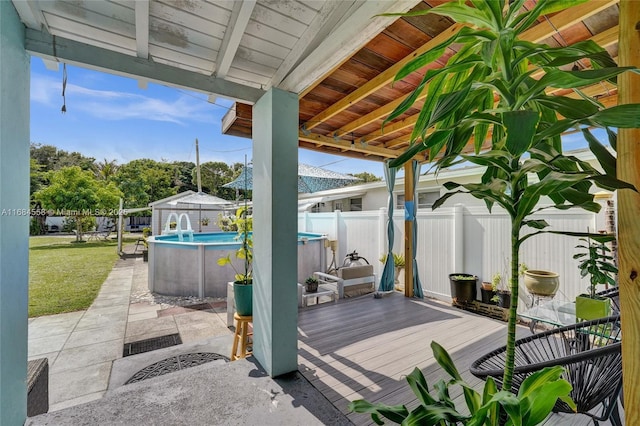 deck featuring a fenced in pool and a yard