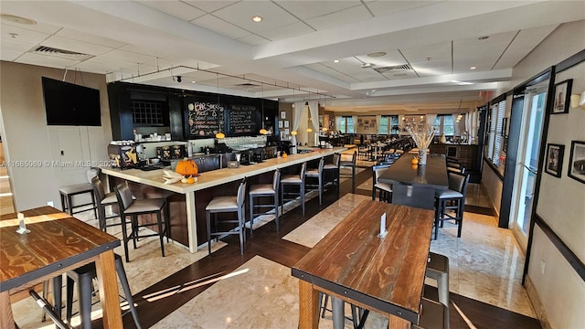 kitchen featuring a breakfast bar and a paneled ceiling