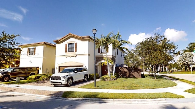 mediterranean / spanish house with a garage and a front lawn