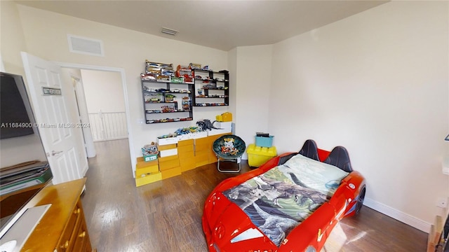 bedroom with dark hardwood / wood-style floors