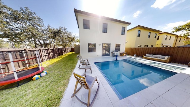 back of house featuring outdoor lounge area, a yard, a fenced in pool, and a patio