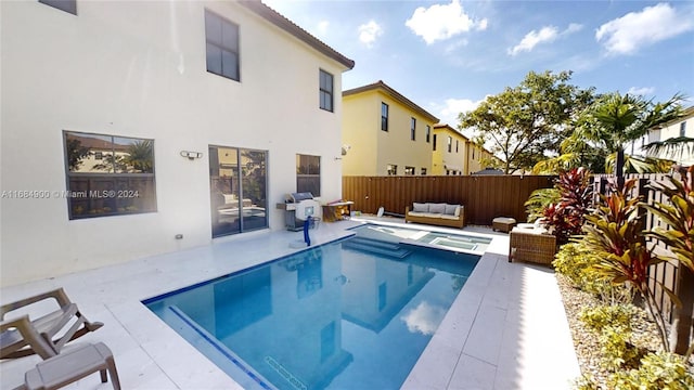 view of pool with an outdoor living space, a patio area, and grilling area