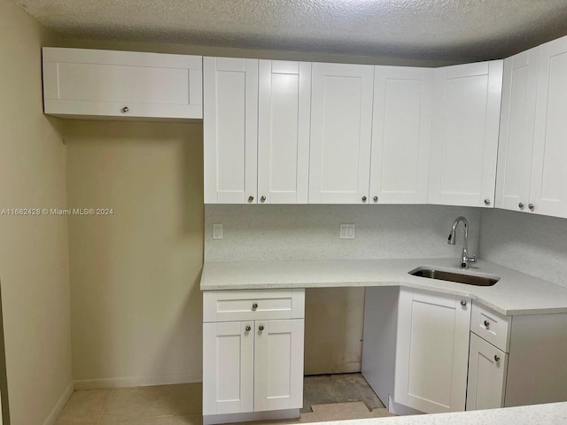 kitchen featuring white cabinetry, a textured ceiling, and sink