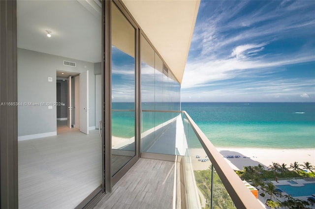 balcony with a water view and a beach view