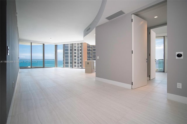 empty room with floor to ceiling windows and a water view