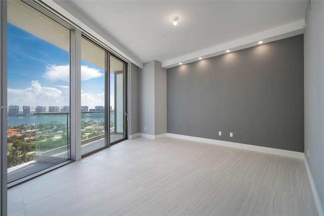 unfurnished room featuring a water view and plenty of natural light