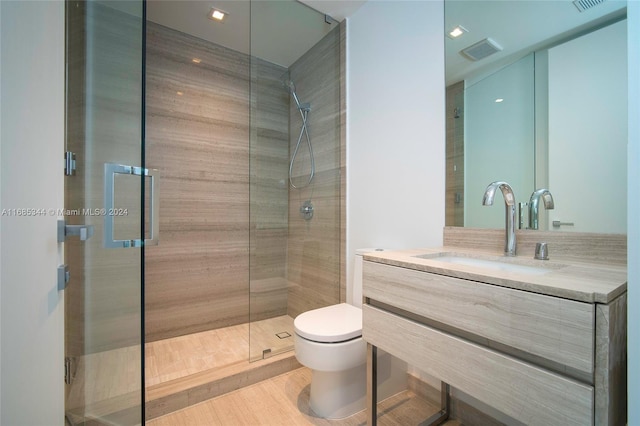 bathroom with vanity, toilet, walk in shower, and wood-type flooring