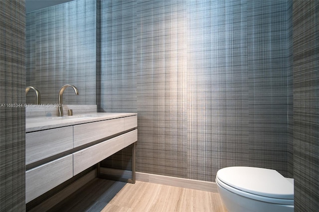 bathroom with vanity, toilet, and hardwood / wood-style flooring