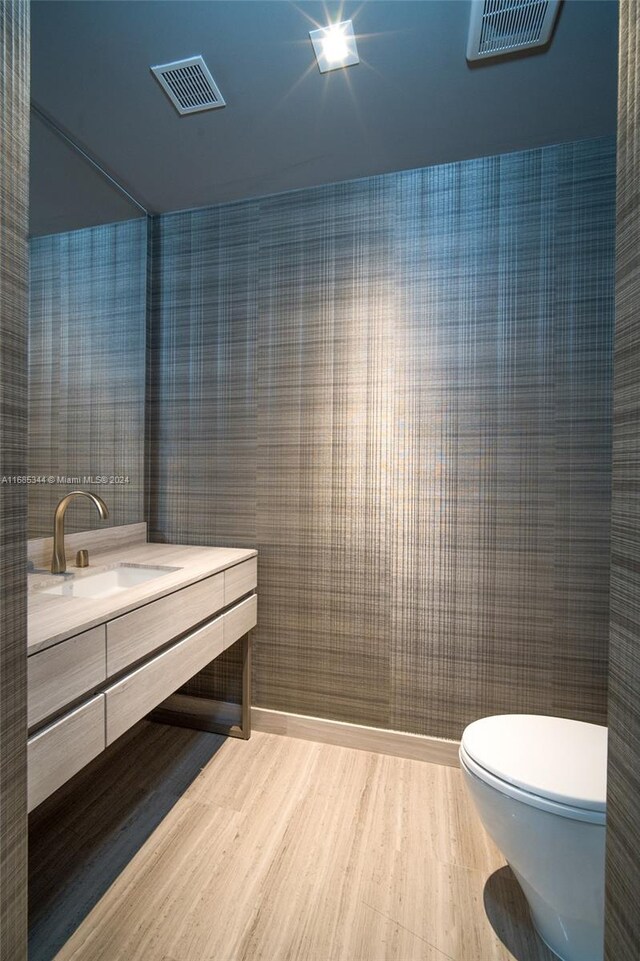 bathroom with vanity, toilet, and hardwood / wood-style floors