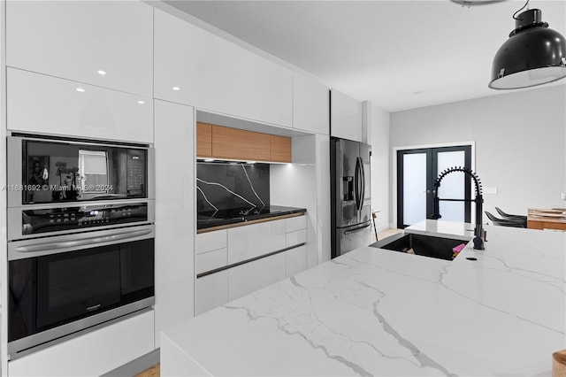 kitchen featuring light stone countertops, sink, white cabinets, and stainless steel appliances