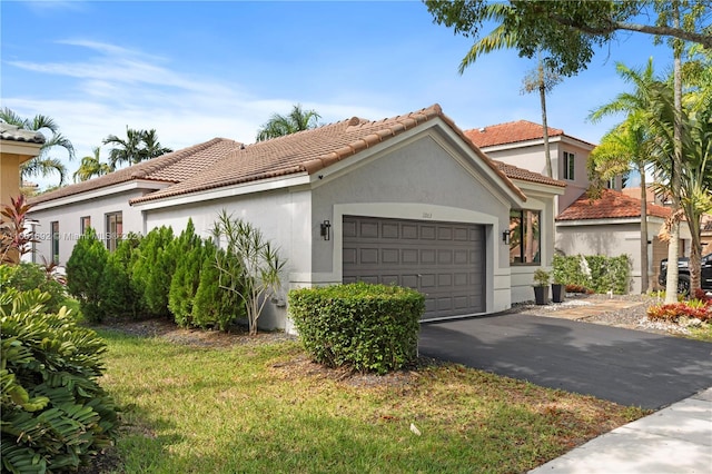 mediterranean / spanish-style home with a garage and a front lawn