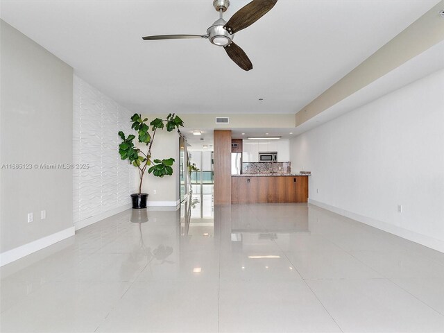 unfurnished living room with ceiling fan