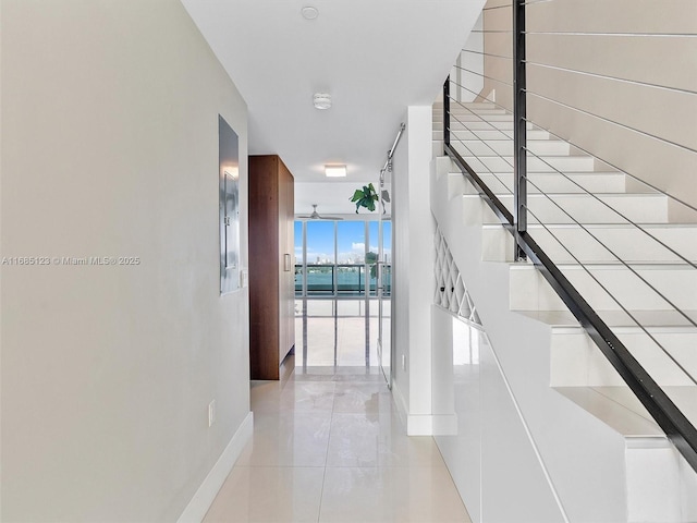 hallway featuring expansive windows and light tile patterned flooring