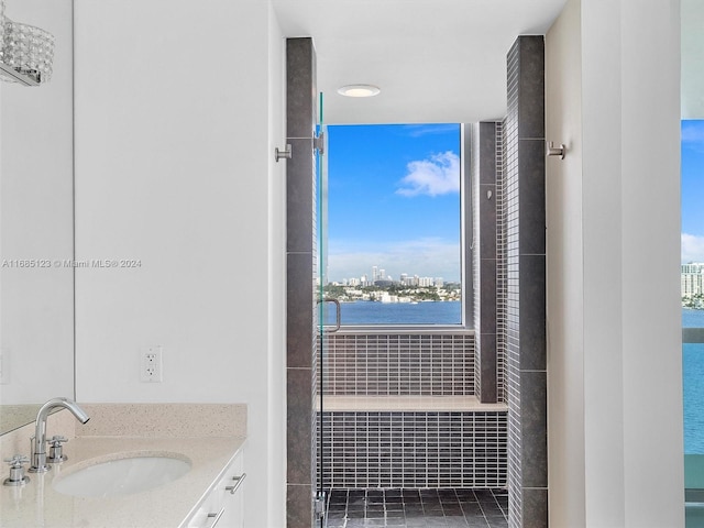 bathroom with vanity, a healthy amount of sunlight, and a water view