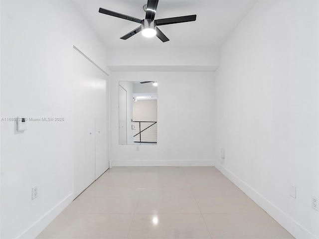 tiled empty room featuring ceiling fan