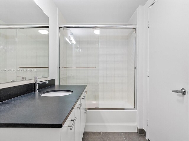 bathroom with vanity, bath / shower combo with glass door, and tile patterned flooring