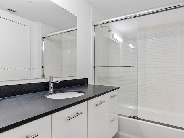 bathroom with vanity and bath / shower combo with glass door