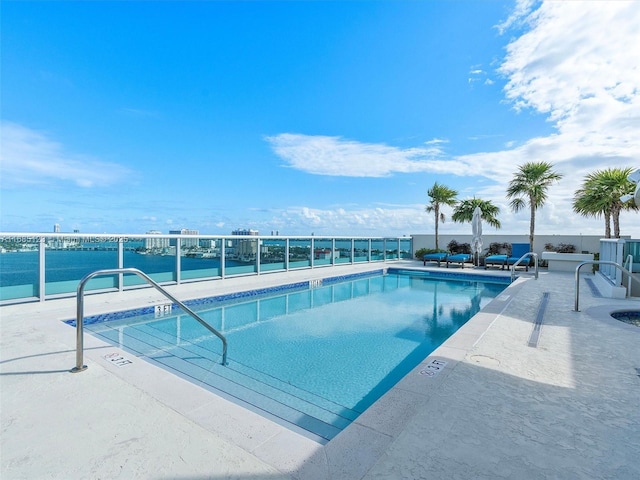 view of pool featuring a patio and a water view