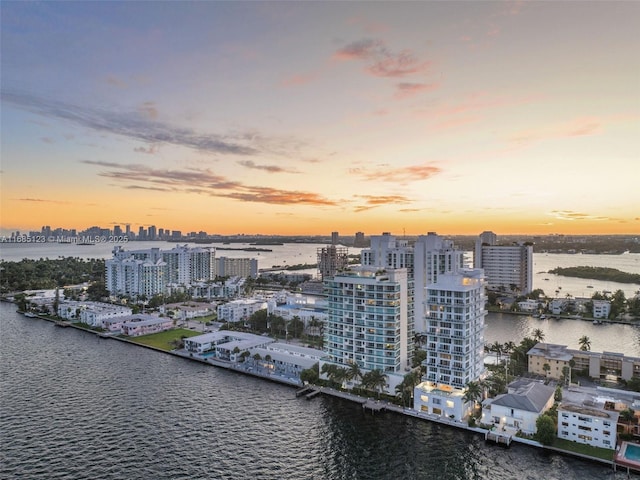 aerial view at dusk featuring a water view