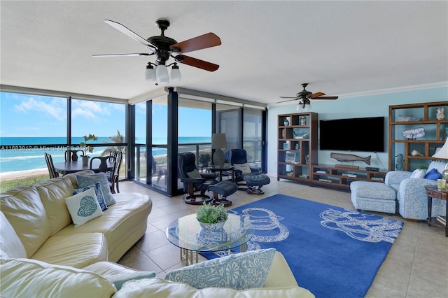 living room with ceiling fan, a textured ceiling, a wall of windows, a water view, and tile patterned flooring